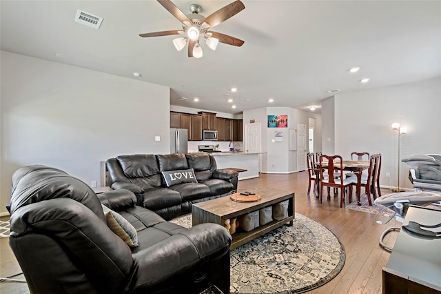 living room featuring light hardwood / wood-style flooring and ceiling fan