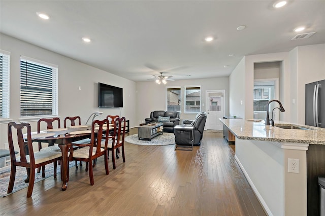 dining space featuring dark wood-type flooring, sink, and ceiling fan