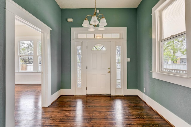 entryway with a chandelier and dark hardwood / wood-style floors