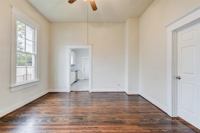 empty room with ceiling fan and dark wood-type flooring