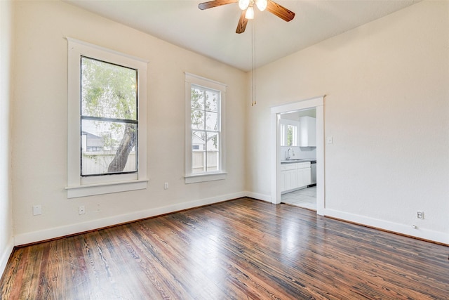 unfurnished room with sink, ceiling fan, and dark hardwood / wood-style floors