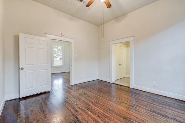 unfurnished room featuring ceiling fan, dark wood-type flooring, and a textured ceiling