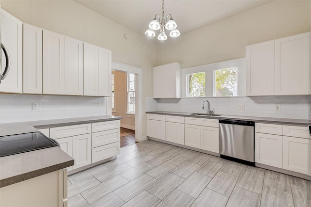 kitchen with sink, dishwasher, white cabinetry, and hanging light fixtures