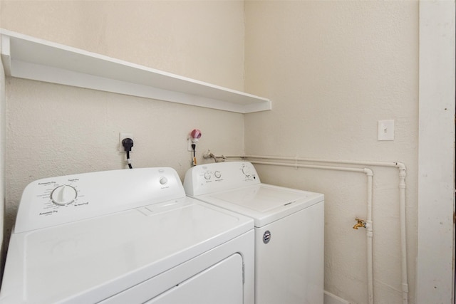 clothes washing area with washing machine and dryer