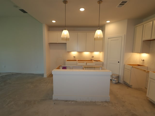 kitchen featuring visible vents, recessed lighting, white cabinetry, and a kitchen island