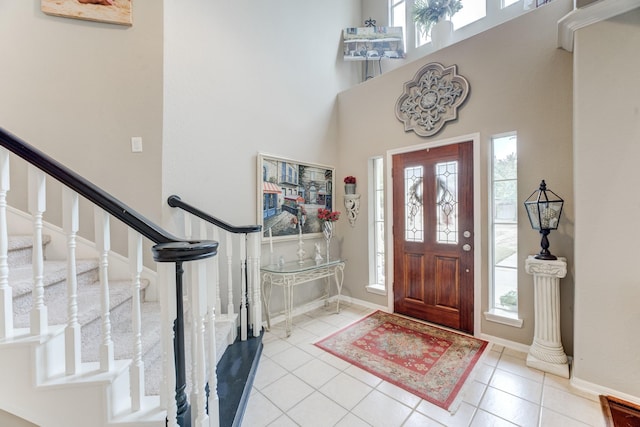 entryway featuring plenty of natural light, a towering ceiling, and light tile patterned floors