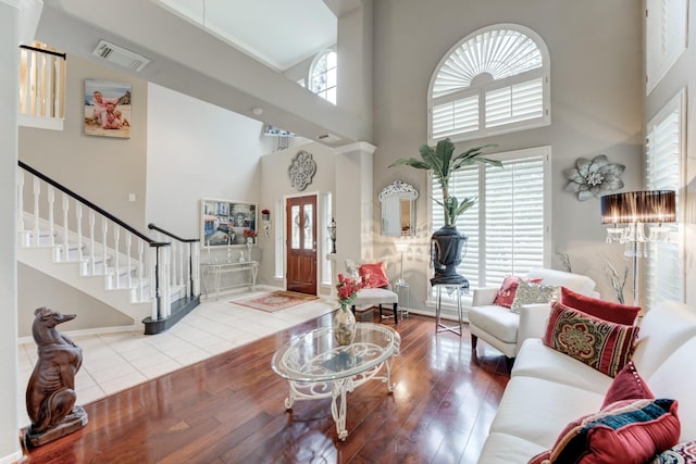 living room with a towering ceiling and hardwood / wood-style flooring