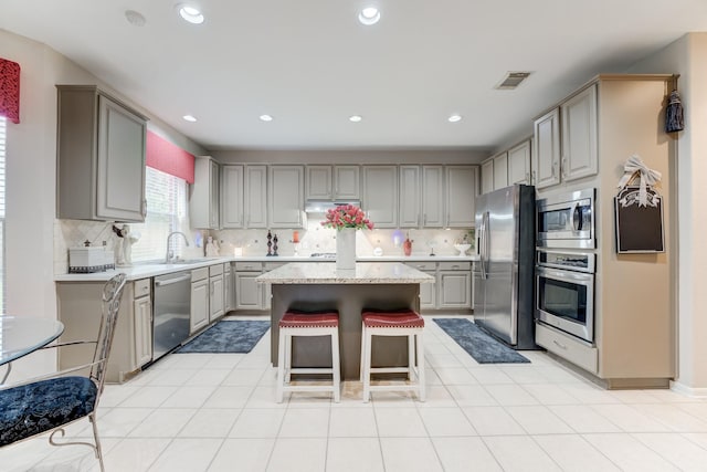 kitchen with backsplash, a center island, gray cabinetry, and stainless steel appliances