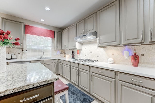 kitchen with sink, gray cabinets, backsplash, and gas stovetop