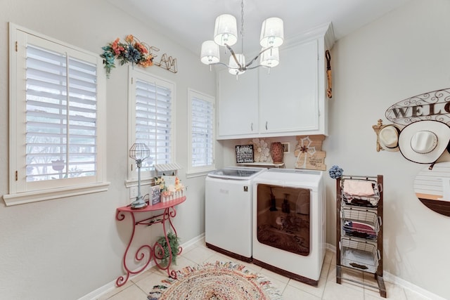 washroom featuring cabinets, washer and clothes dryer, a notable chandelier, and light tile patterned flooring