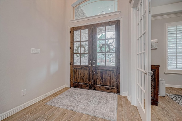 foyer entrance featuring french doors and crown molding