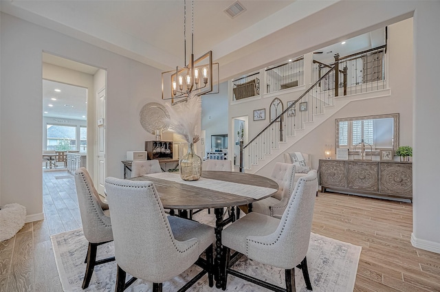 dining room with an inviting chandelier and light hardwood / wood-style flooring