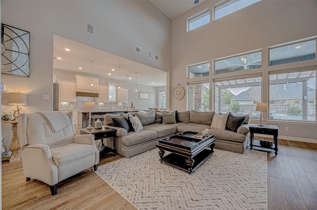 living room featuring light hardwood / wood-style floors and a high ceiling