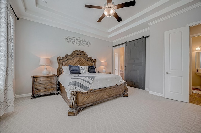 bedroom featuring ornamental molding, a tray ceiling, carpet flooring, ceiling fan, and a barn door