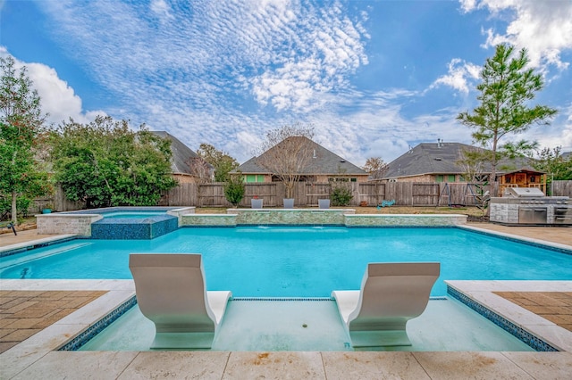 view of swimming pool featuring an in ground hot tub, pool water feature, and area for grilling