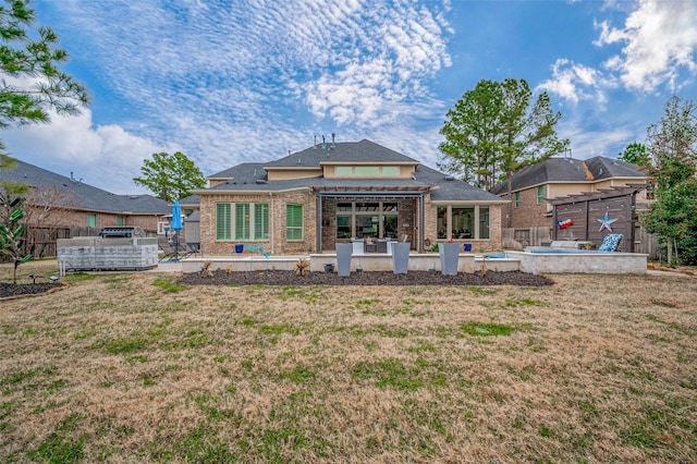 back of property with a lawn, a patio area, and a jacuzzi