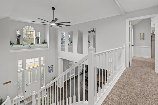 stairs with vaulted ceiling, carpet floors, crown molding, and ceiling fan