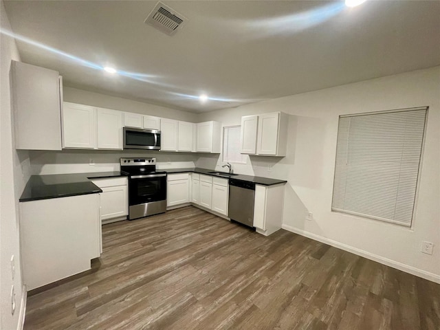 kitchen featuring white cabinets, dark hardwood / wood-style floors, appliances with stainless steel finishes, and sink