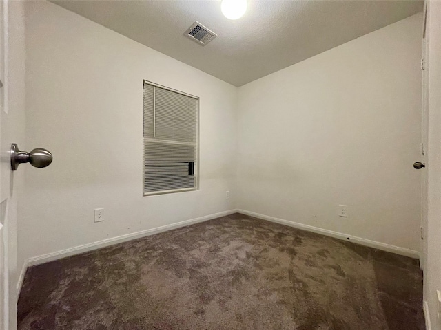 unfurnished room with dark carpet