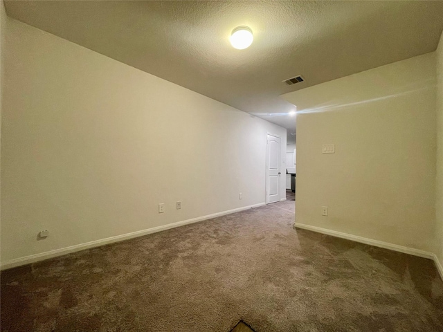 carpeted empty room with a textured ceiling