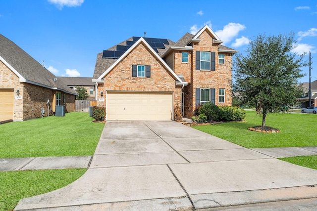 view of front of property with a garage, cooling unit, a front lawn, and solar panels