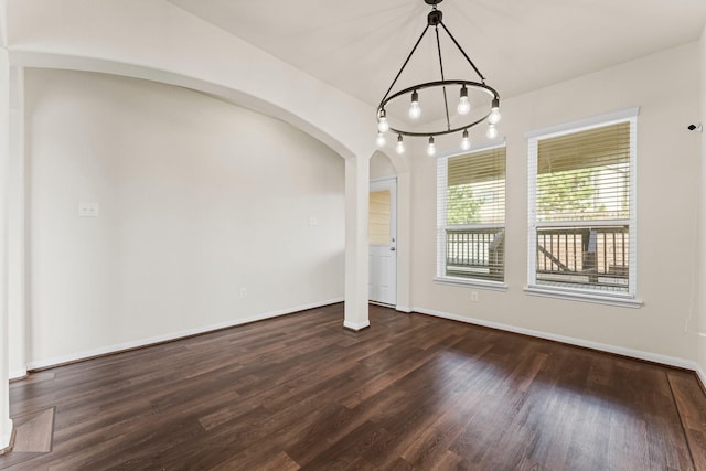 unfurnished dining area featuring dark wood-type flooring and a notable chandelier