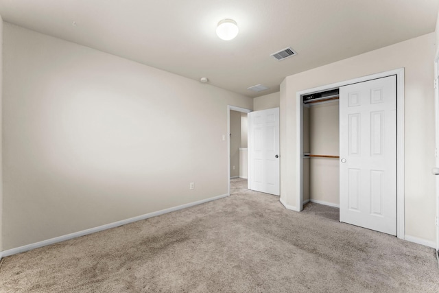 unfurnished bedroom featuring light colored carpet and a closet