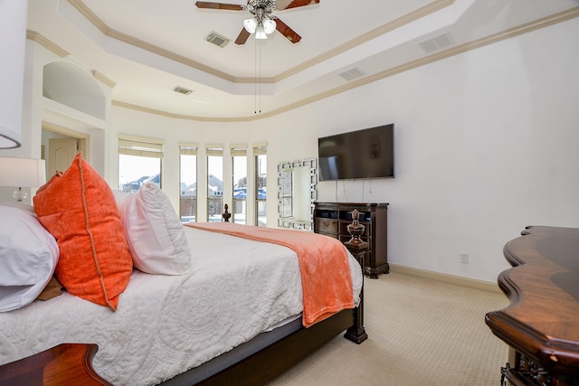 carpeted bedroom with crown molding, ceiling fan, and a tray ceiling