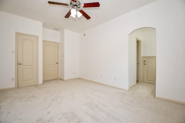 empty room featuring ceiling fan and light carpet