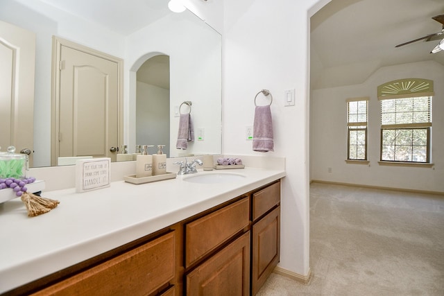 bathroom with ceiling fan, vanity, and vaulted ceiling