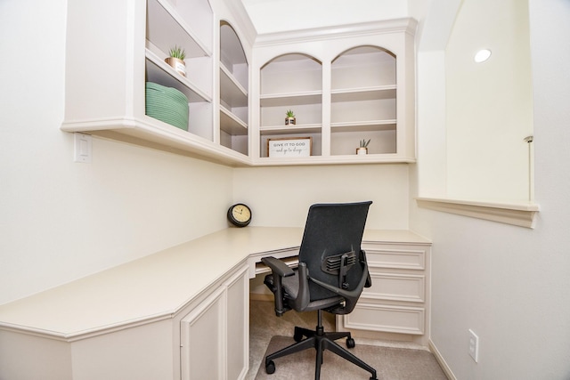 office space with built in desk and light carpet