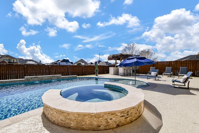 view of swimming pool with a patio area, pool water feature, and an in ground hot tub