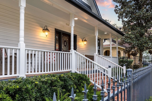 exterior entry at dusk featuring covered porch