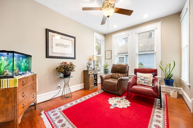 sitting room with wood-type flooring and ceiling fan