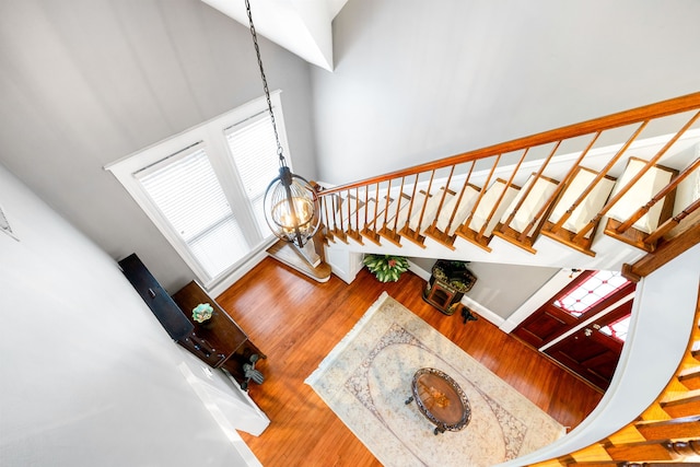 stairs featuring a towering ceiling and hardwood / wood-style floors