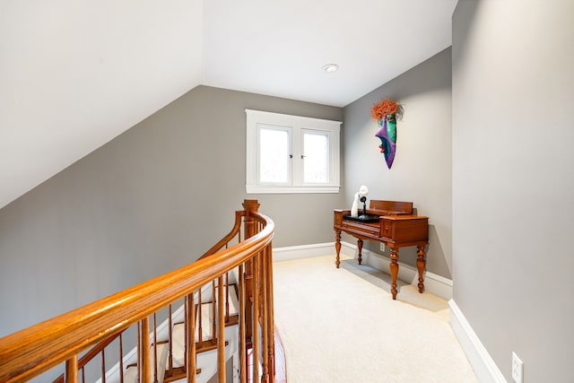 corridor with carpet floors and vaulted ceiling