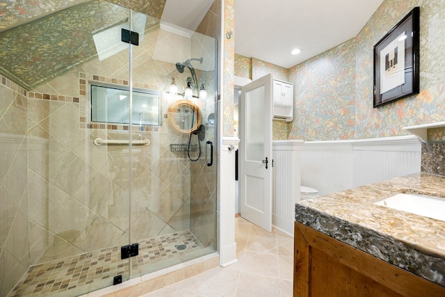 bathroom featuring vanity, a shower with shower door, and tile patterned flooring