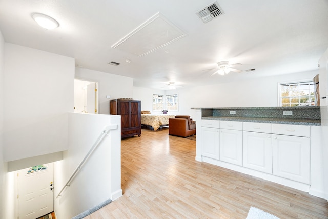 kitchen with white cabinetry, a wealth of natural light, and light wood-type flooring