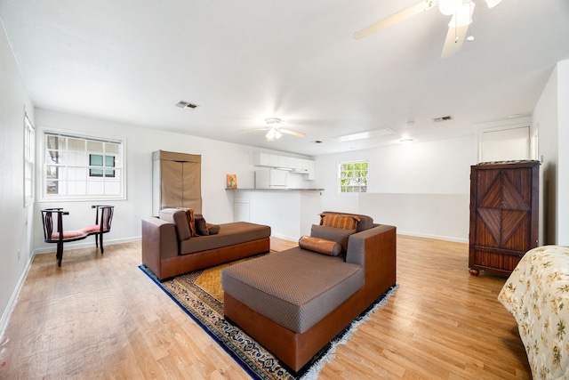 living room with ceiling fan and light hardwood / wood-style flooring