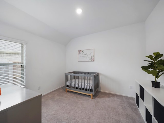 carpeted bedroom with a nursery area and vaulted ceiling