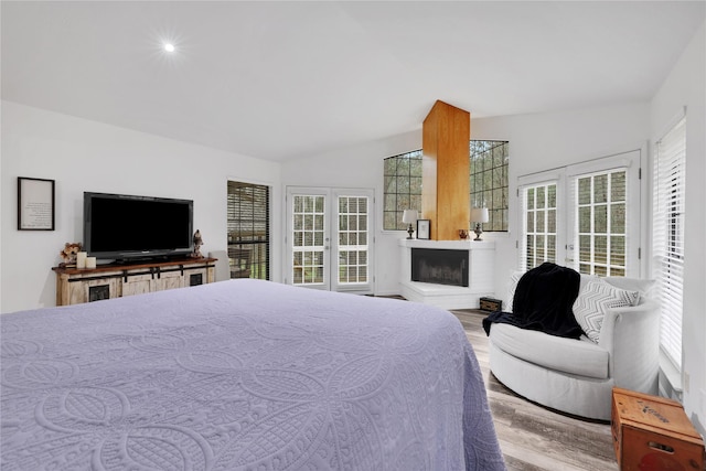 bedroom featuring access to outside, multiple windows, lofted ceiling, and french doors