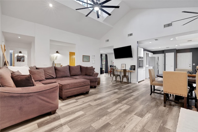 living room with ceiling fan, high vaulted ceiling, and light hardwood / wood-style floors