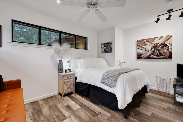 bedroom with ceiling fan, hardwood / wood-style floors, and track lighting