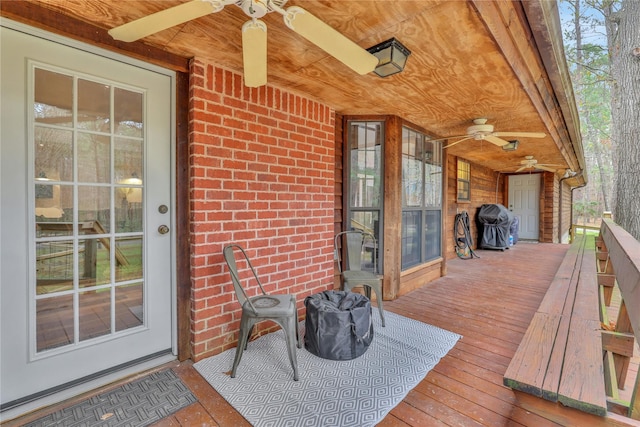 wooden terrace with ceiling fan and area for grilling