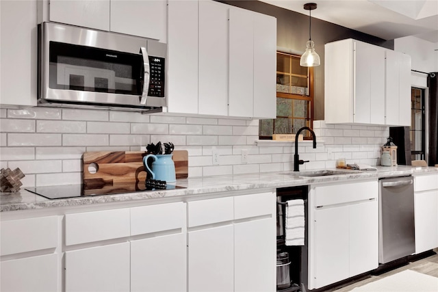 kitchen featuring backsplash, white cabinets, and hanging light fixtures