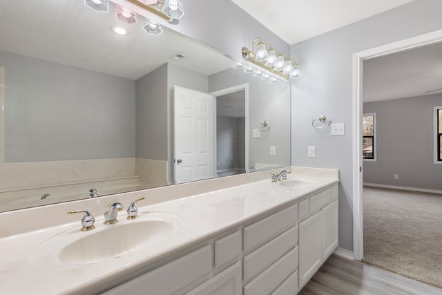 bathroom featuring hardwood / wood-style flooring, vanity, and a bathtub