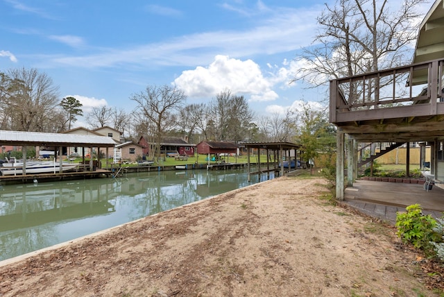 view of yard featuring a deck with water view and a boat dock