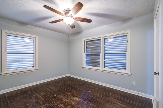 spare room featuring ceiling fan, dark wood-type flooring, and a textured ceiling