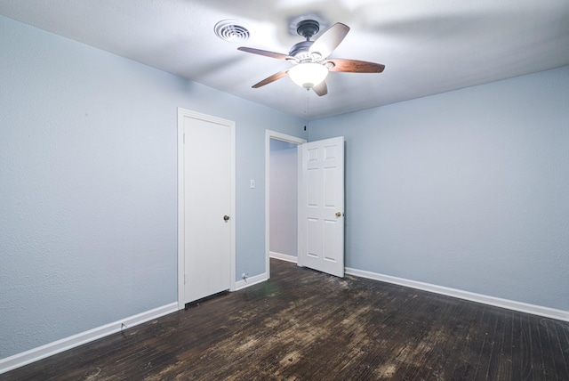 spare room with ceiling fan and dark hardwood / wood-style flooring