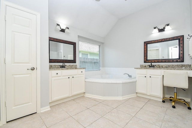 bathroom featuring vanity, vaulted ceiling, tile patterned floors, and a washtub